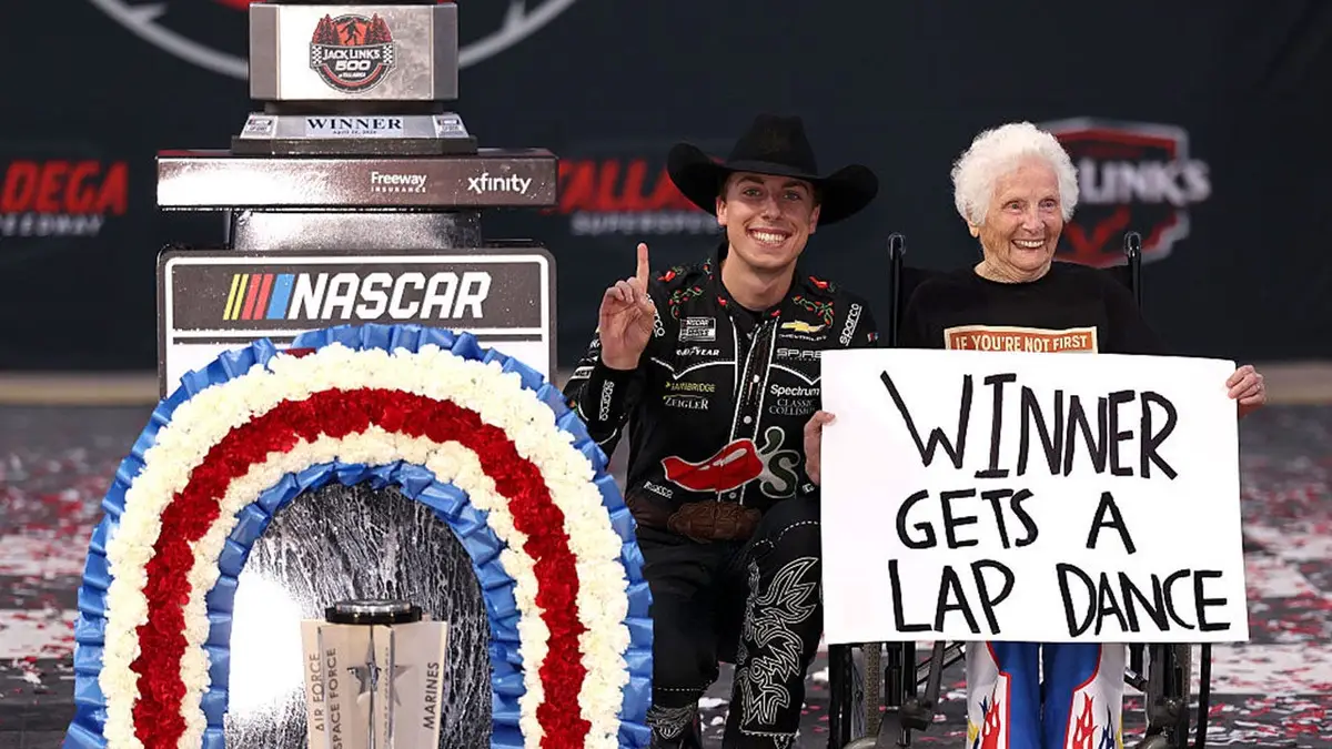 Carson Hocevar posing with guest in victory lane at Talladega Superspeedway