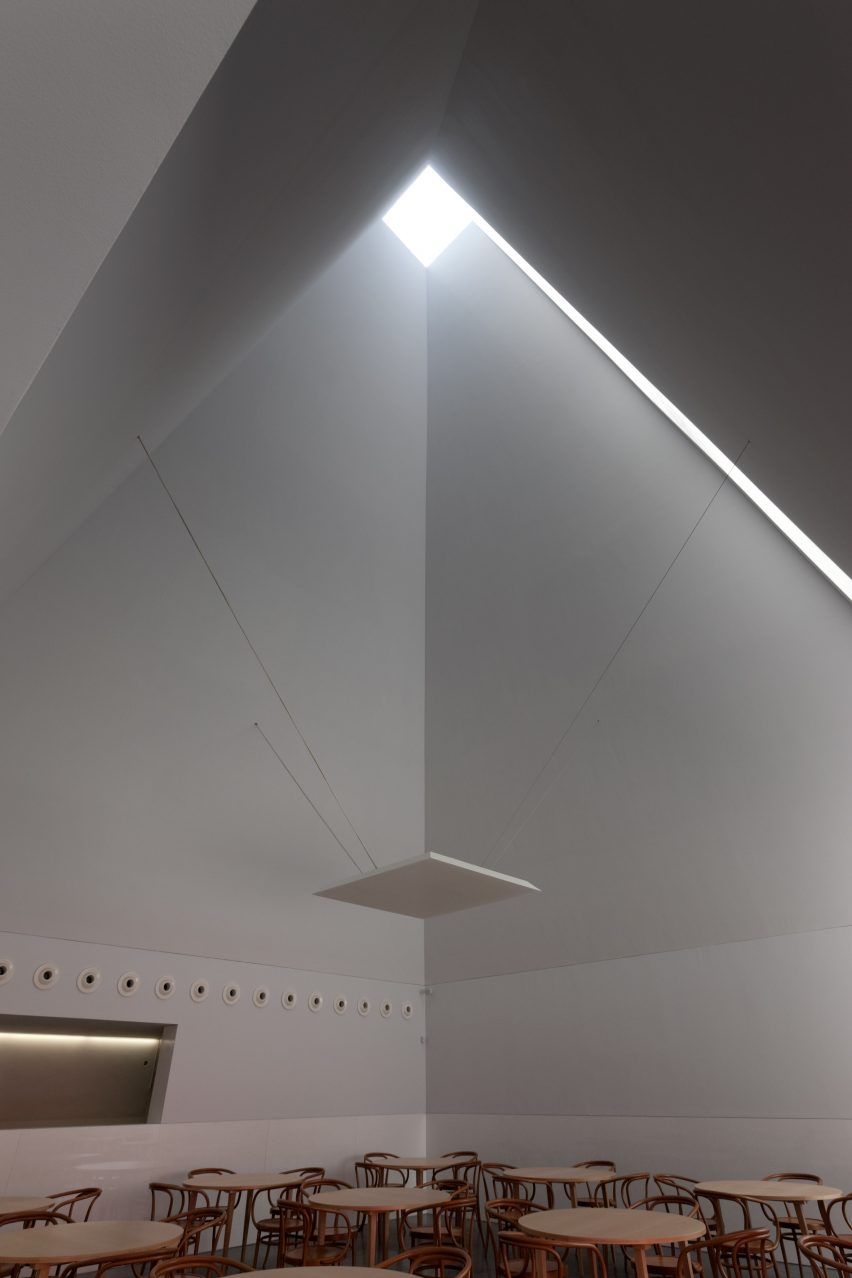 Tall gallery space with a pyramidal ceiling and overhead skylight bringing natural light into the room