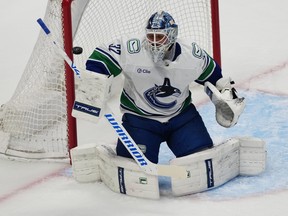 Vancouver Canucks goaltender Kevin Lankinen deflects a shot in the first period of an NHL hockey game against the Colorado Avalanche Wednesday, April 1, 2026, in Denver.