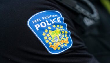 Police car near a park area in Brampton, highlighting the ongoing search for a suspect in a sexual assault case.