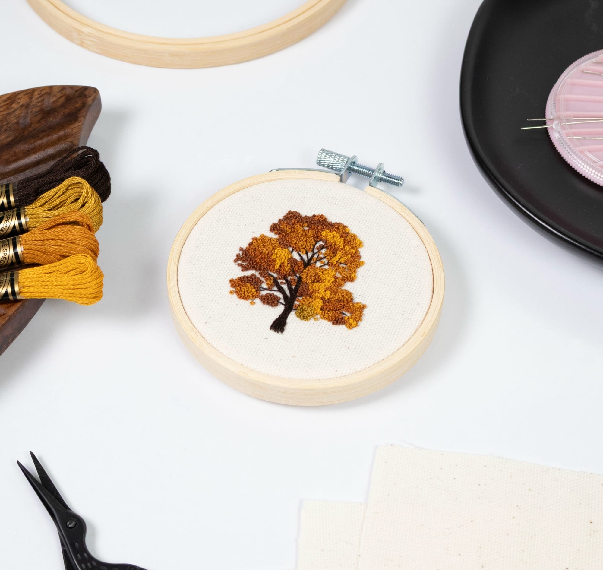 an autumn tree embroidery with supplies around