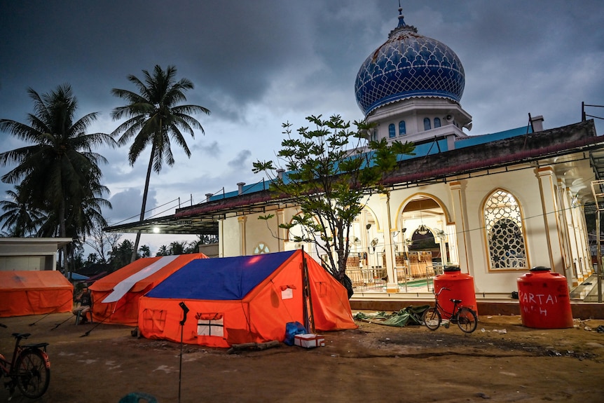 A tent set up next to a mosque.