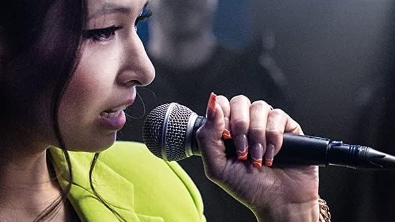 A woman holding a Shure SM58 microphone.