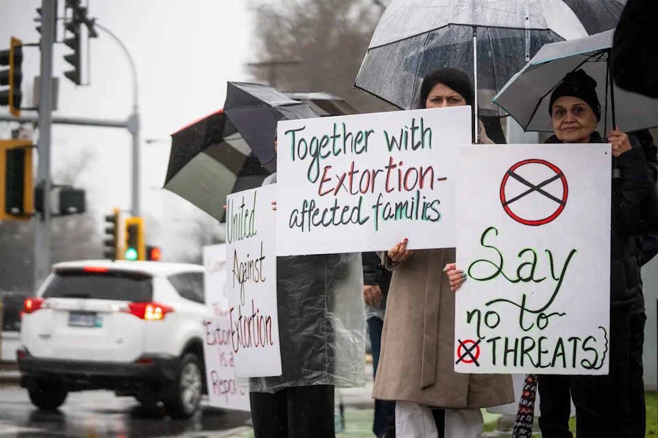 Surrey residents hold signs during a demonstration against extortion-related violence in Surrey, British Columbia, on Monday, Feb., 2, 2026.