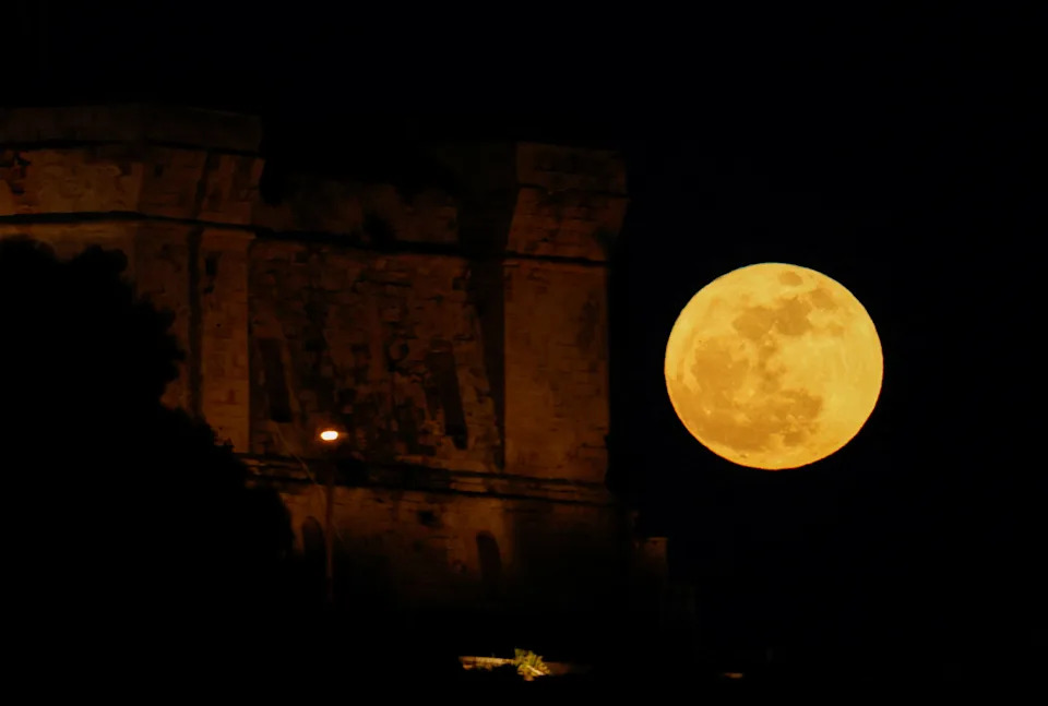 A full moon known as the "Flower Moon" rises behind the 17th century Fort St Lucian, as seen from Birzebbuga, Malta, May 12, 2025.