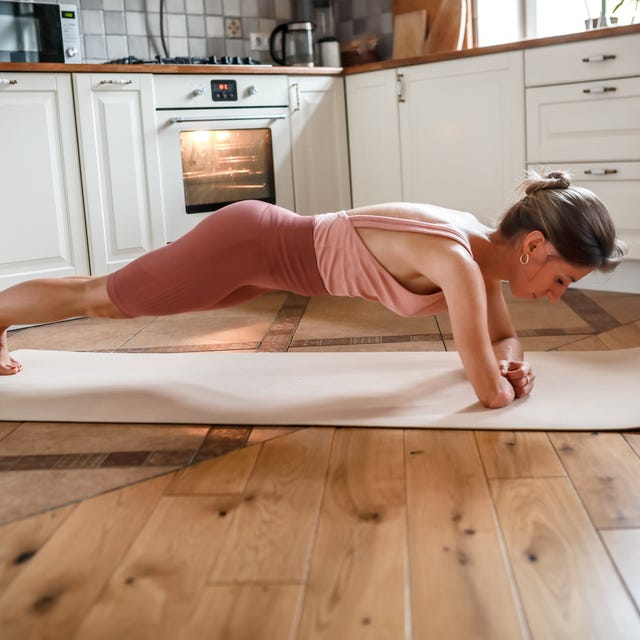 Unyielding Power: Amputee Woman's Yoga Practice in the Comfort of Her Kitchen, Mastering Plank Pose with One Arm. Unyielding Power: Amputee Woman's Yoga Practice in the Comfort of Her Kitchen, Mastering Plank Pose with One Arm.
