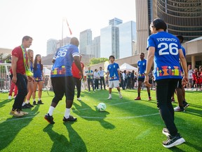 People playing soccer on green grass in Toronto