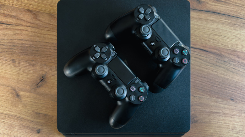 2 PS controllers kept on a PS4 Pro console