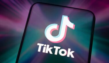 TikTok logo on phone with purple and green lights