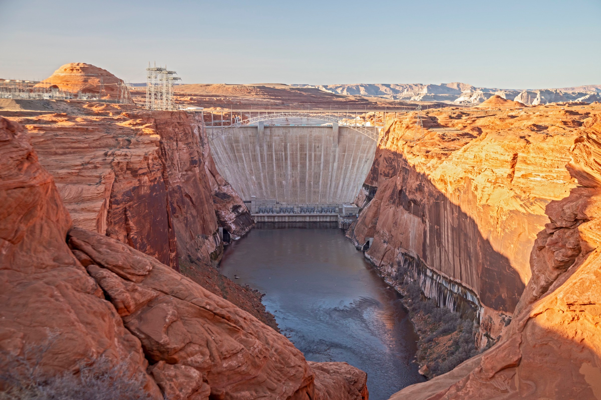 dam across a canyon with low water levels below it