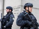 Officers part of Toronto Police's new rapid response counter-terrorism unit stand guard outside a place of worship after shooting incidents at synagogues. 