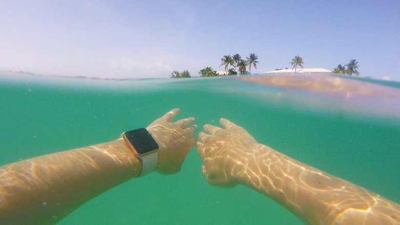 person swimming with apple watch on, hands visible before them