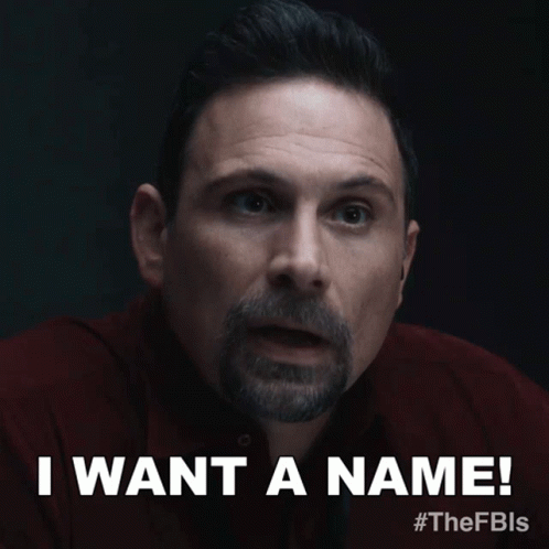 a man with a beard says " i want a name " in a dark room