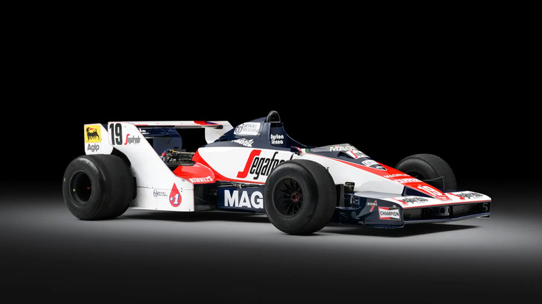 The Toleman TG183B-05 under a spotlight in a dark studio