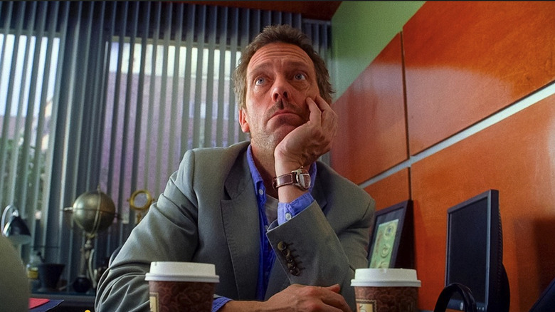 Hugh Laurie as Dr. Gregory House leans on his elbow in House