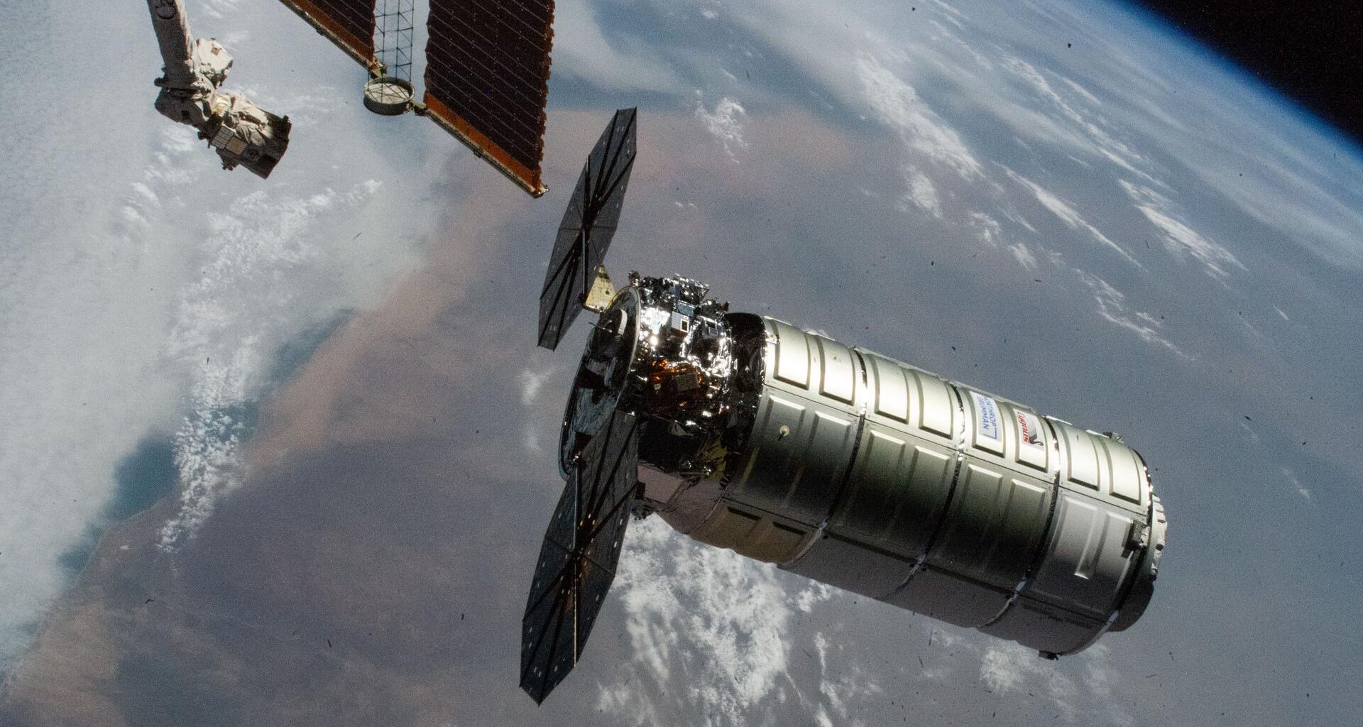 Northrop Grumman's Cygnus XL cargo craft, carrying over 11,000 pounds of new science and supplies for the Expedition 73 crew, is pictiured moments before its capture with the International Space Station's Canadarm2 robotic arm. Both spacecraft were orbiting 257 miles above Namibia. Cygnus XL is Northrop Grumman's expanded version of its previous Cygnus cargo craft increasing its payload capacity and pressurized cargo volume.