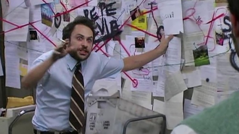 Charlie smoking a cigarette next to a conspiracy board in It's Always Sunny in Philadelphia