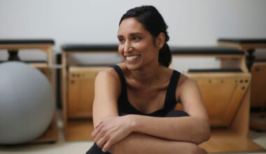 Woman smiling sitting down doing bodyweight Pilates workout
