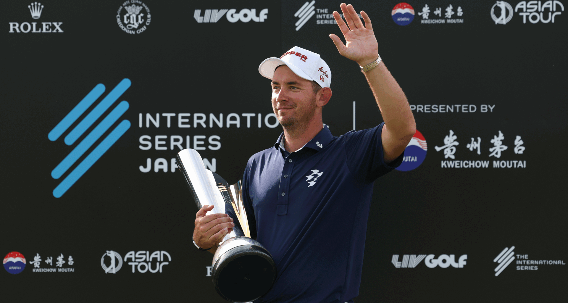 Lucas Herbert waves to fans while holding the International Series Japan trophy in 2025