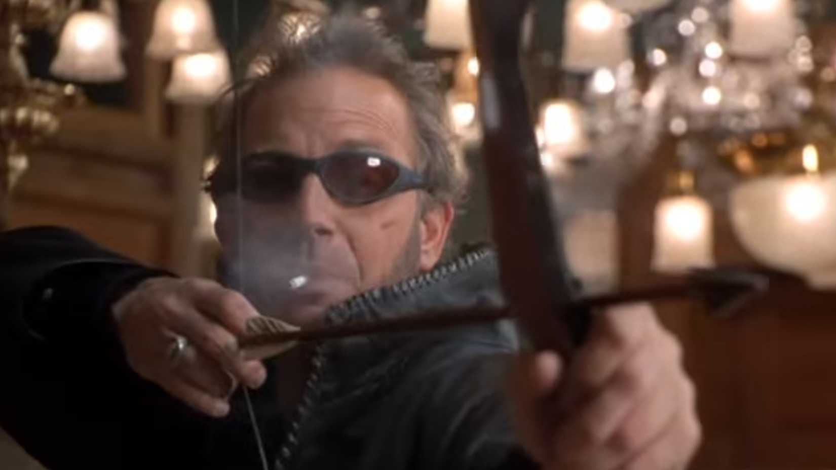 Kevin Costner as Murphy holding a bow smoking a cigarette in 3000 miles to graceland