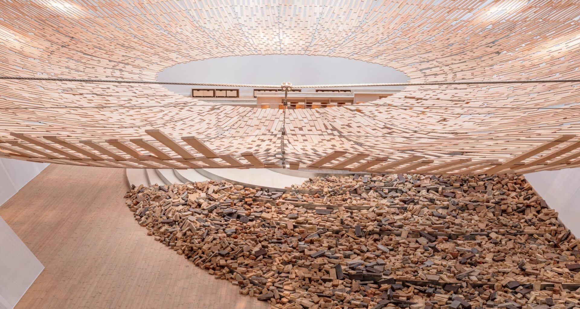 light streams through a wooden canopy in a large scale installation of wood and brick by Kengo Kuma