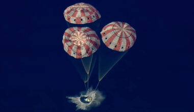 A space capsule splashes down in the ocen.