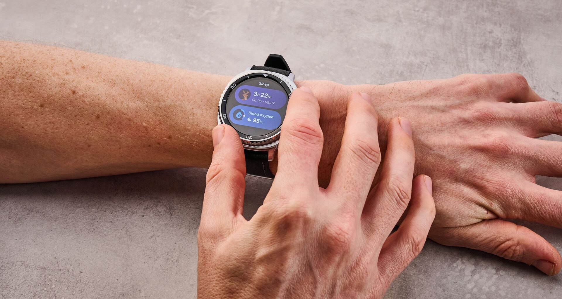 The Samsung Galaxy Watch 8 Classic on a man's wrist; he turns its dial to select its sleep features.