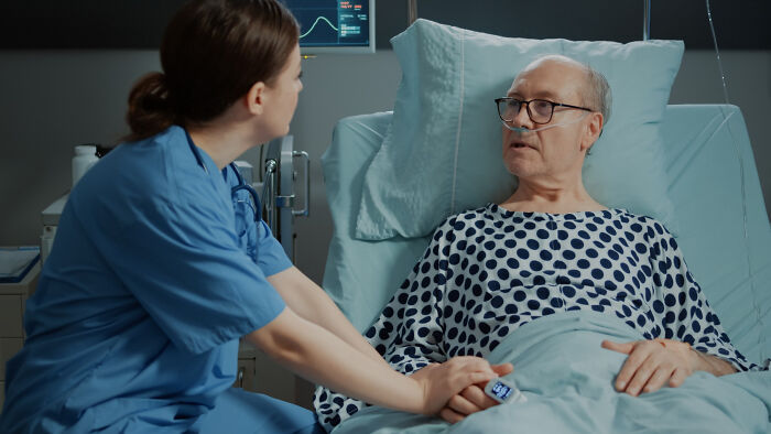 Surgical staff caring for an elderly patient in hospital bed, discussing confessions made while patients were under sedation.