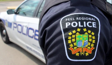 Police car with flashing lights in a Brampton neighborhood at night, symbolizing local law enforcement response