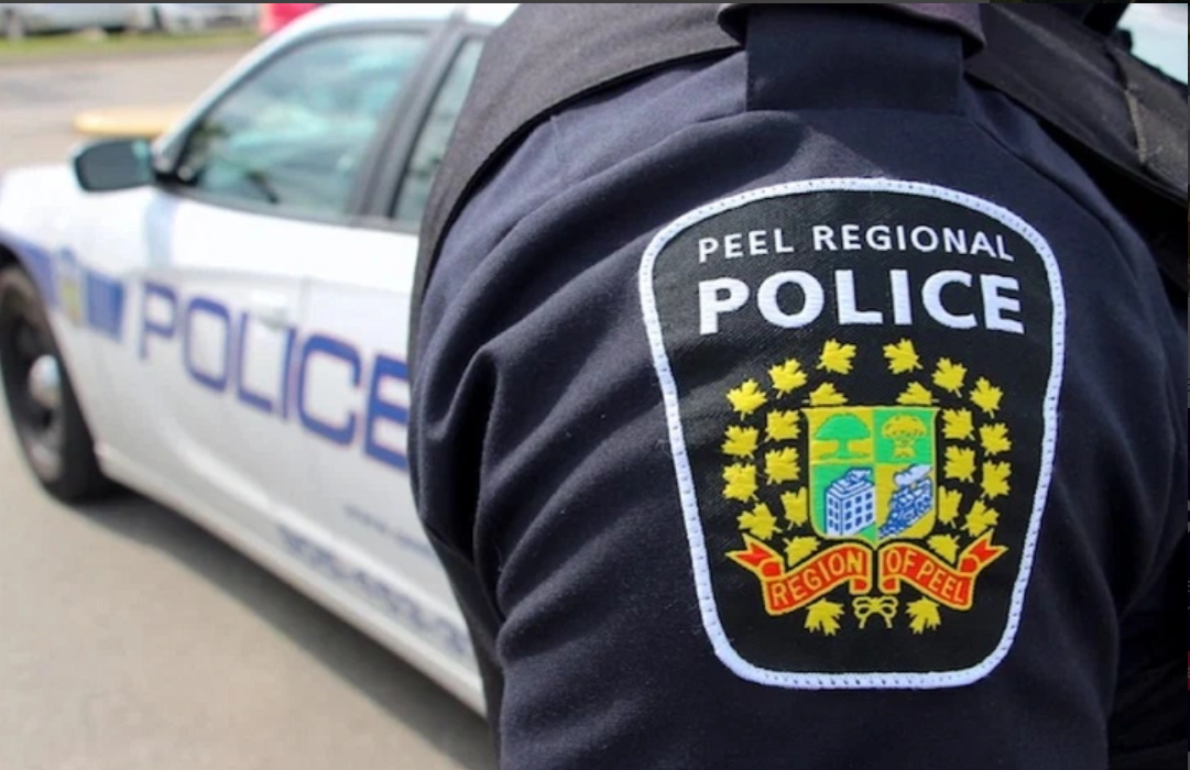 Police car with flashing lights in a Brampton neighborhood at night, symbolizing local law enforcement response