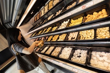 A customer builds their dish with some of the ingredients at the Big Way Hot Pot restaurant in New Westminster.
