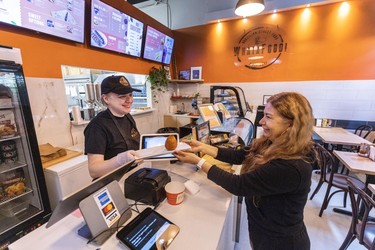 Ana Figueiroa, left, and customer Silvana Navarro inside WhataFood, a Brazilian street food restaurant in New Westminster.