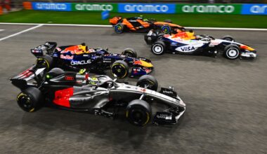 Four Formula 1 cars racing on a track, showcasing vibrant team liveries and sponsorship logos.