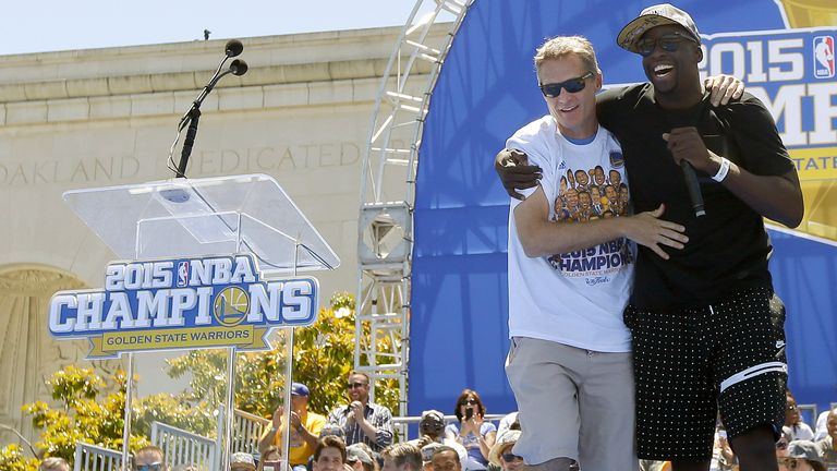 Golden State Warriors' Draymond Green brings head coach Steve Kerr to 
front of the stage while speaking during a champions parade in 2015