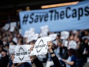 Vancouver Whitecaps fans hold signs before the first half of an MLS soccer match against the Colorado Rapids in Vancouver, on Saturday, April 25, 2026.