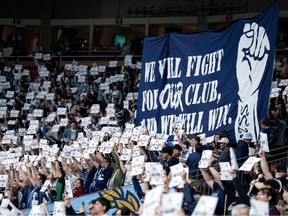 Vancouver Whitecaps fans hold signs before the first half of an MLS soccer match against the Colorado Rapids in Vancouver, on Saturday, April 25, 2026.
