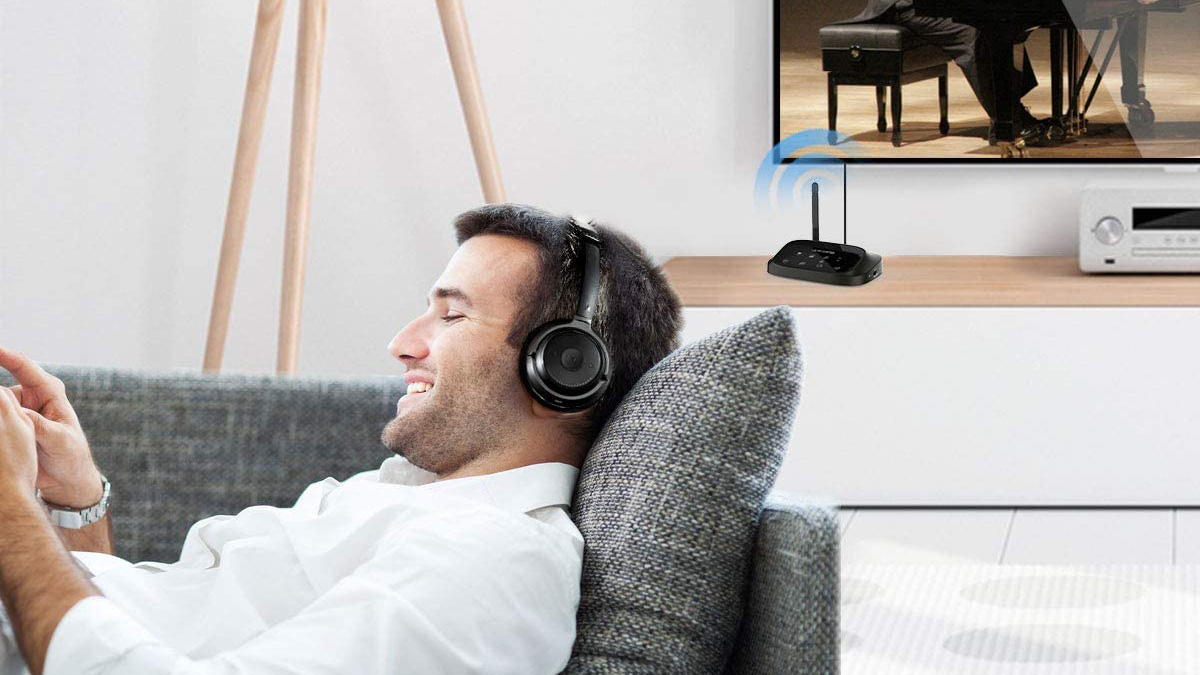 Man laying on a couch listening to audio with Bluetooth headphones