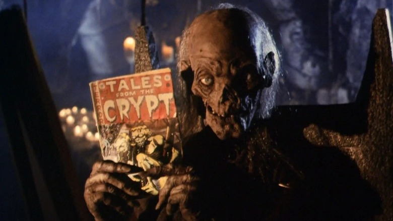 The Cryptkeeper (John Kassir) holds up a comic book in Tales from the Crypt