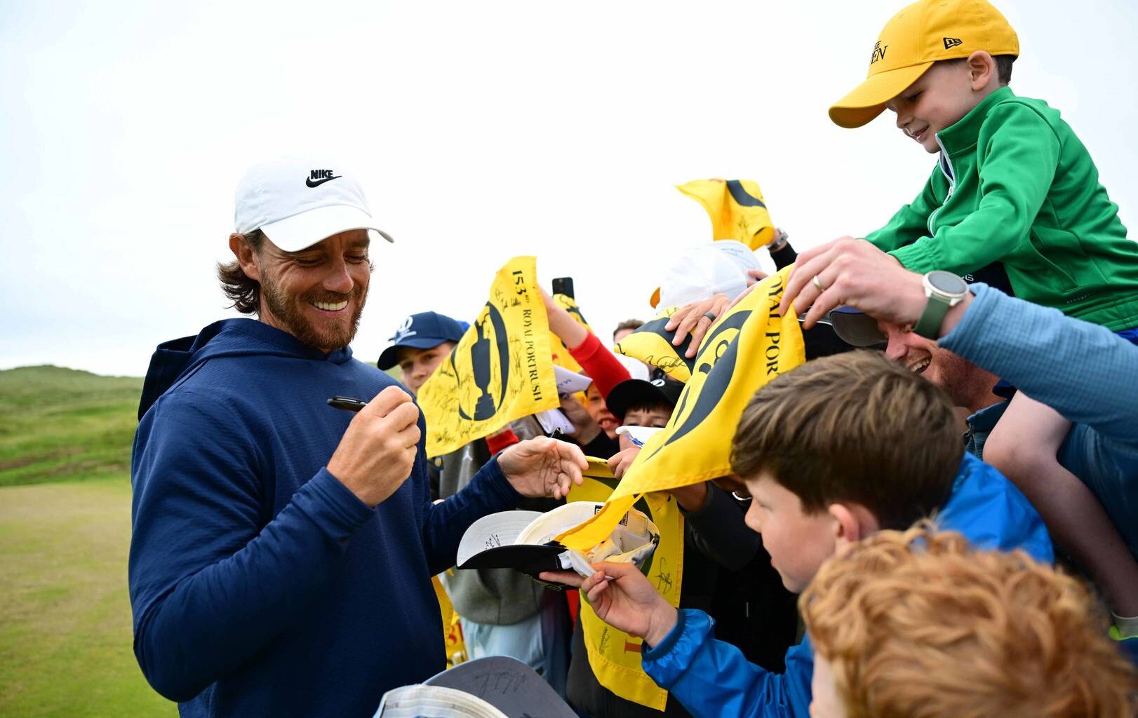 Tommy Fleetwood signs autographs for fans at The Open.