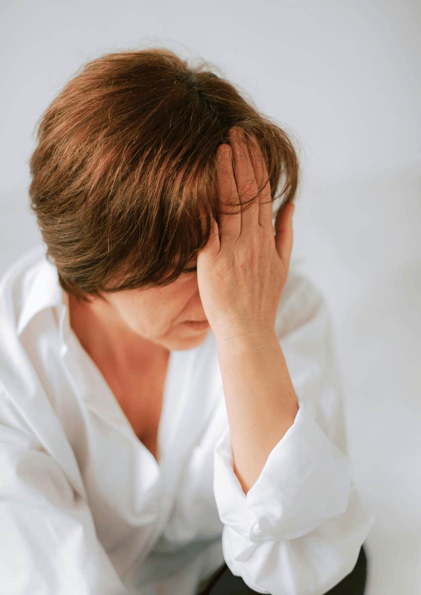 upset middle age woman covering her face