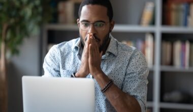 An investor looks surprised while studying something on a laptop.