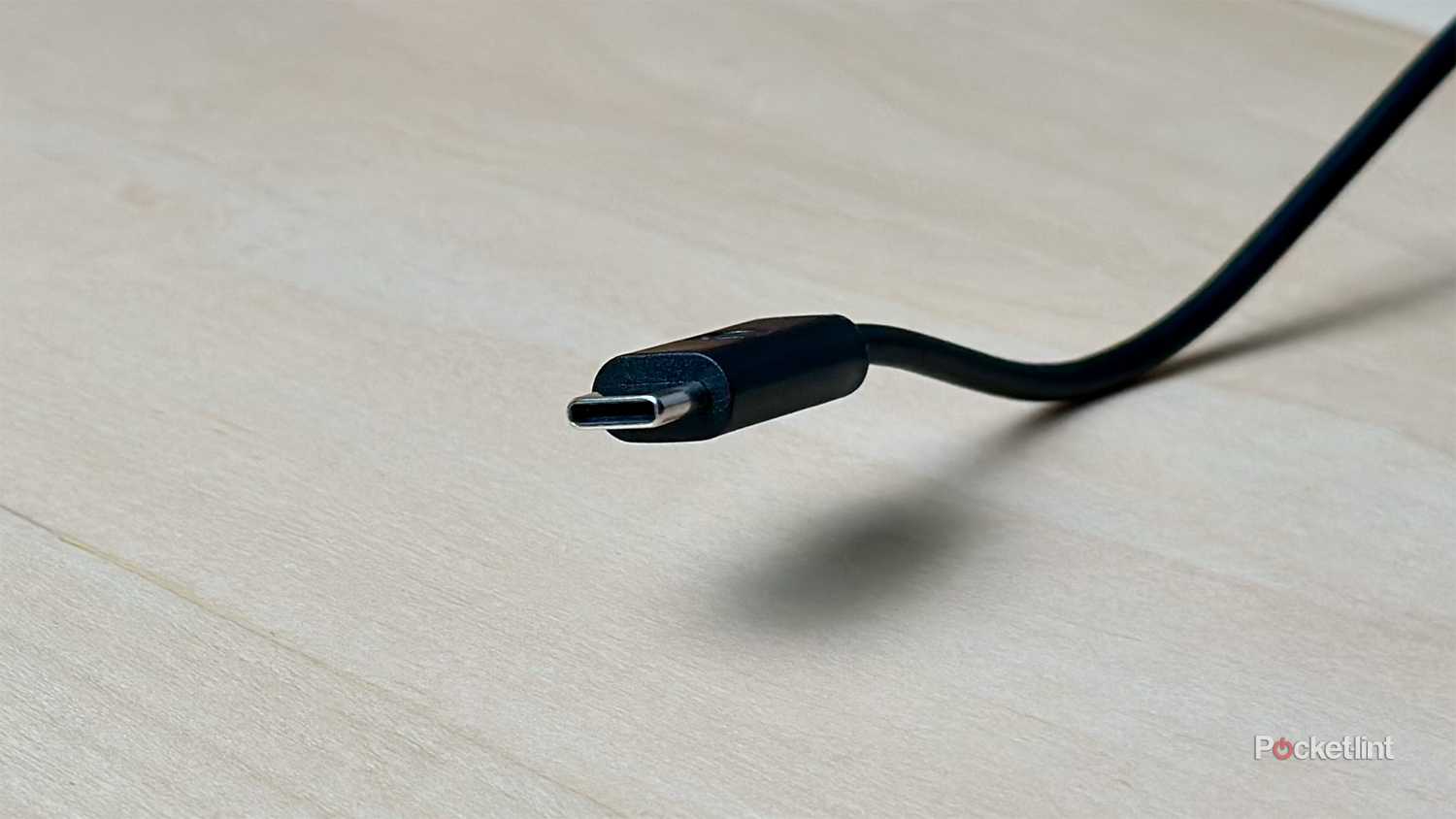 USB Type-C cable on wood desk.