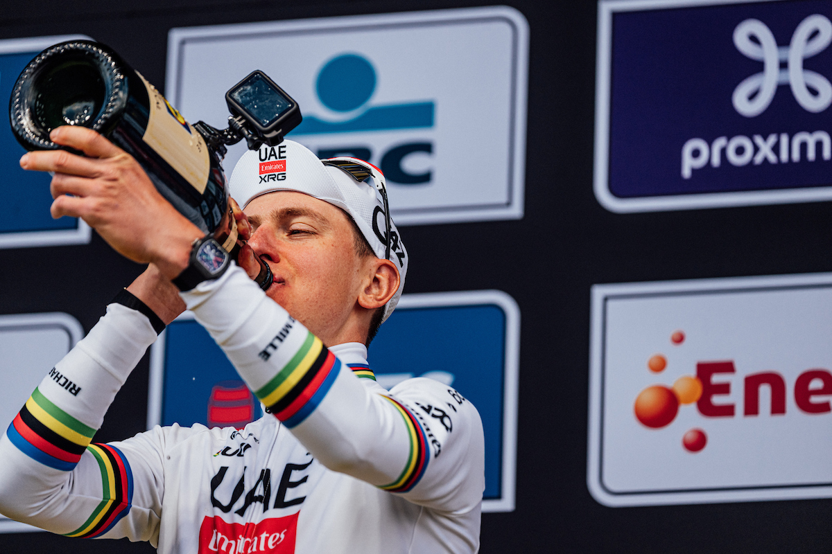 Pogačar drinking champagne on the podium of the Tour of Flanders