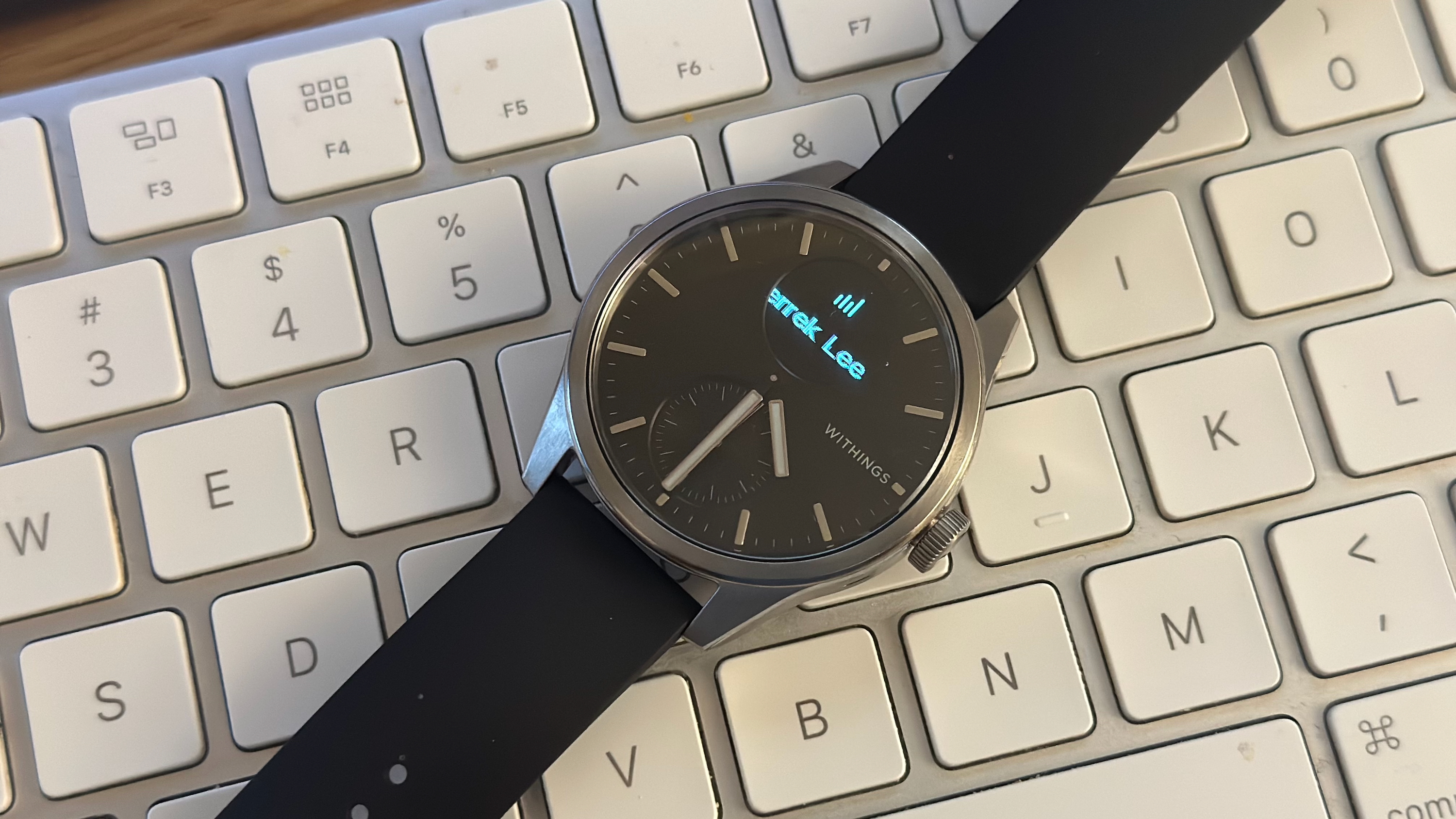 The Withings ScanWatch 2 showing a fraction of a Slack notification, the sender "Derrek Lee."