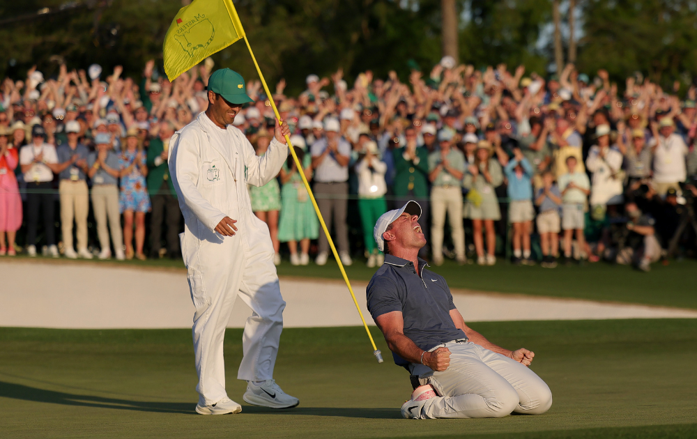 Rory McIlroy of Northern Ireland celebrates winning with caddie Harry Diamond after winning the 2025 Masters