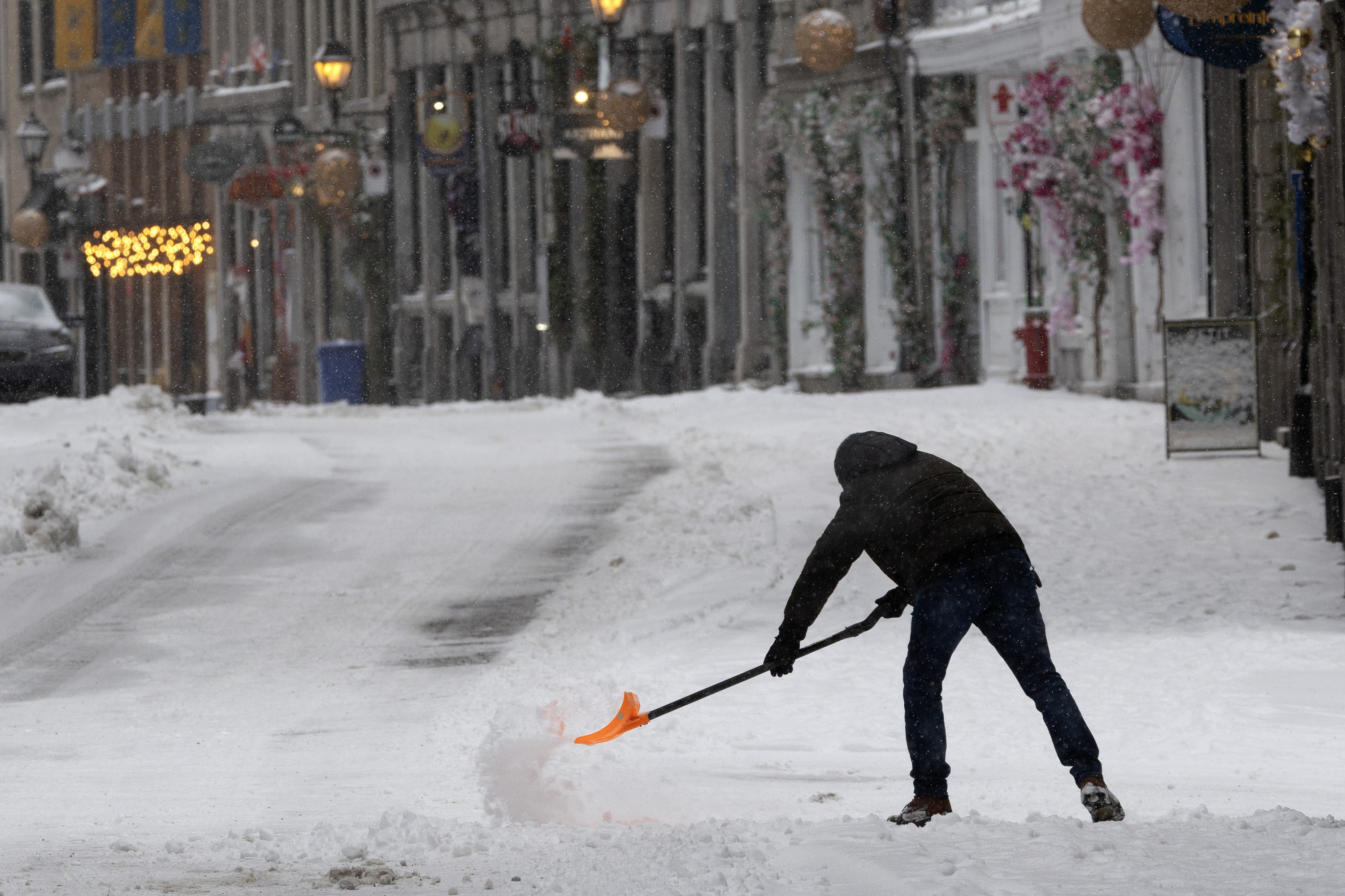 A man shovels unplowed sidewalks in Old Montreal