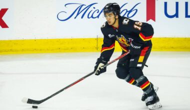Mar 7, 2026; Calgary, Alberta, CAN; Calgary Flames defenseman Zayne Parekh (19) skates with the puck against the Carolina Hurricanes during the first period at Scotiabank Saddledome. Mandatory Credit: Sergei Belski-Imagn Images