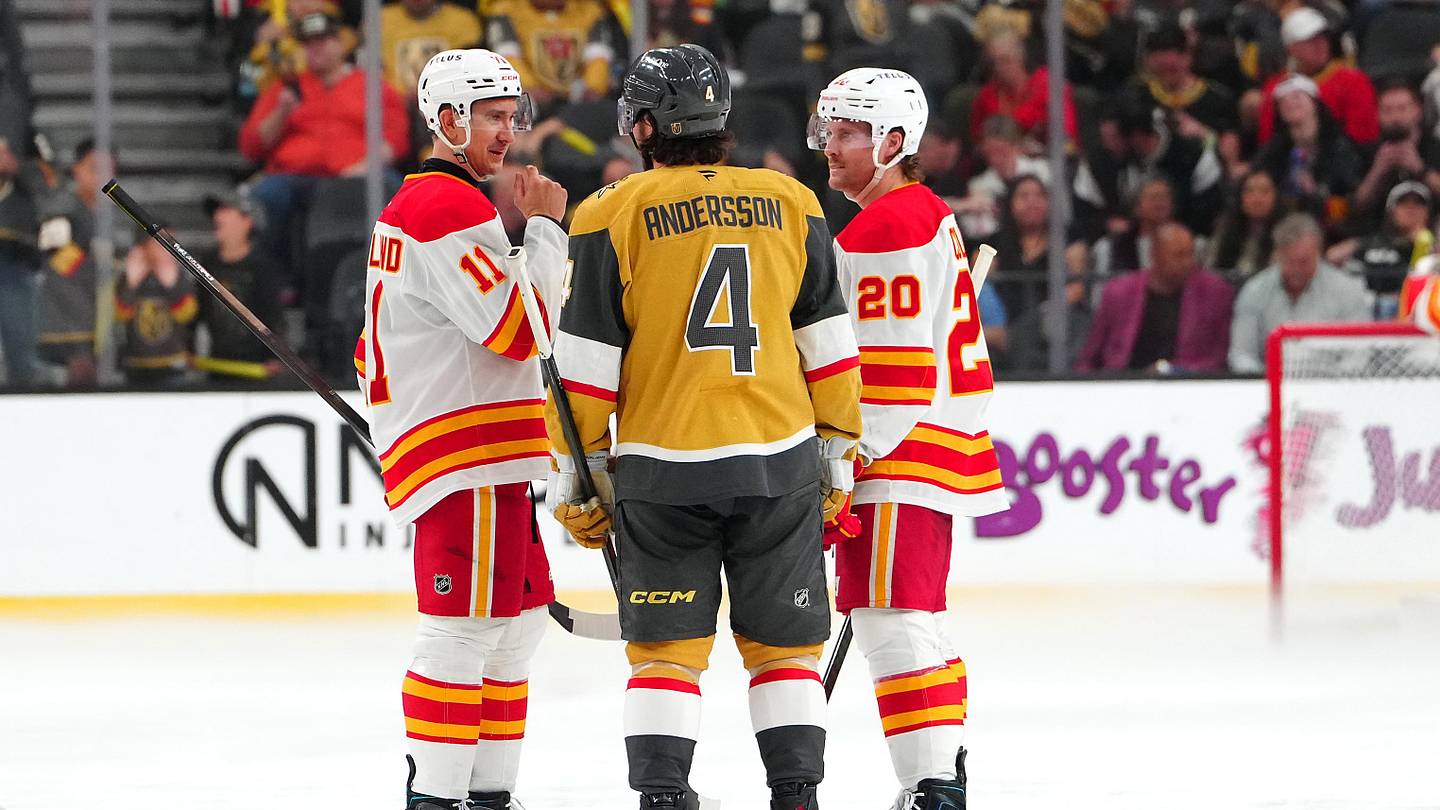 Apr 2, 2026; Las Vegas, Nevada, USA; Vegas Golden Knights defenseman Rasmus Andersson (4) talks with Calgary Flames center Mikael Backlund (11) an left wing Blake Coleman (20) as repairs are made to the ice before the start of the third period at T-Mobile Arena. Mandatory Credit: Stephen R. Sylvanie-Imagn Images