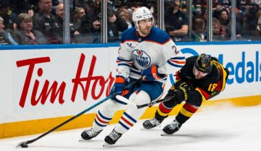 Jan 17, 2026; Vancouver, British Columbia, CAN; Vancouver Canucks forward Drew O'Connor (18) stick checks Edmonton Oilers defenseman Evan Bouchard (2) in the second period at Rogers Arena. Mandatory Credit: Bob Frid-Imagn Images
