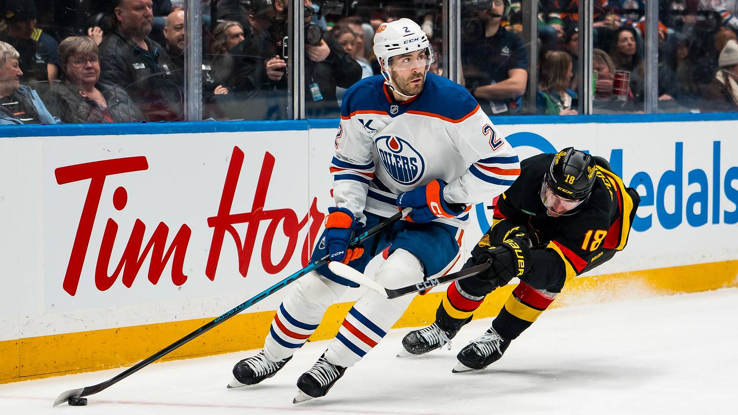 Jan 17, 2026; Vancouver, British Columbia, CAN; Vancouver Canucks forward Drew O'Connor (18) stick checks Edmonton Oilers defenseman Evan Bouchard (2) in the second period at Rogers Arena. Mandatory Credit: Bob Frid-Imagn Images